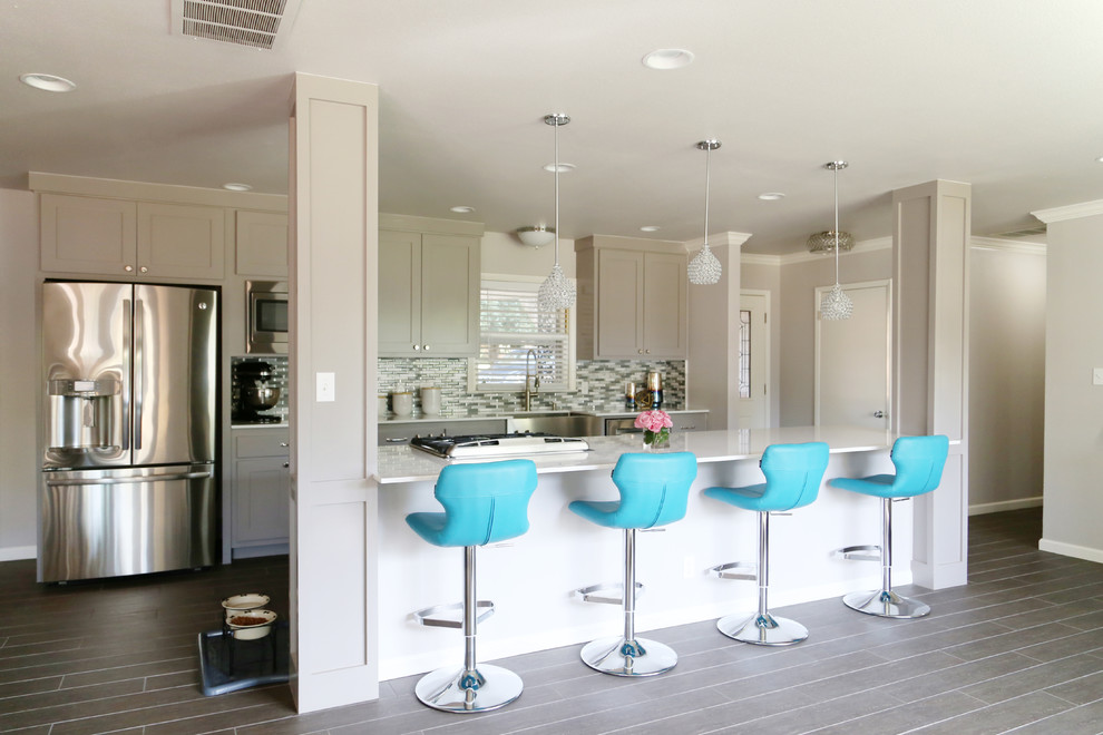 Eat-in kitchen - mid-sized transitional u-shaped porcelain tile and gray floor eat-in kitchen idea with a farmhouse sink, shaker cabinets, gray cabinets, glass sheet backsplash, stainless steel appliances, an island, quartz countertops and blue backsplash