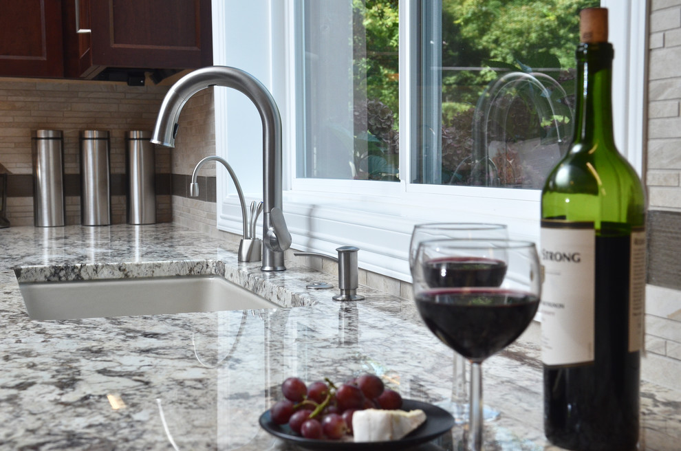 Mid-sized transitional medium tone wood floor eat-in kitchen photo in Portland with an undermount sink, recessed-panel cabinets, medium tone wood cabinets, granite countertops, beige backsplash, porcelain backsplash, stainless steel appliances and an island