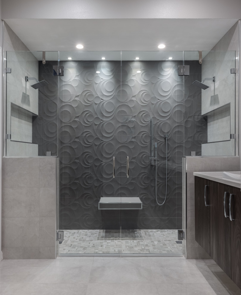 Bathroom - mid-sized contemporary master gray tile and ceramic tile double-sink bathroom idea in Tampa with brown cabinets, a one-piece toilet, gray walls, a drop-in sink, granite countertops, a hinged shower door, white countertops and a floating vanity