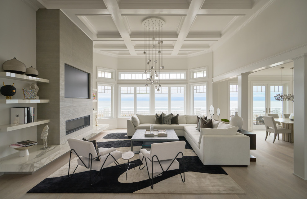 Example of a beach style light wood floor, beige floor and coffered ceiling living room design with white walls, a ribbon fireplace and a wall-mounted tv