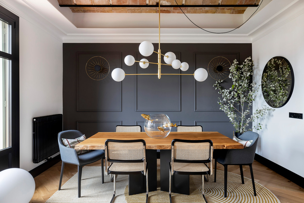 Immagine di una sala da pranzo aperta verso il soggiorno tradizionale di medie dimensioni con pareti grigie, pavimento in legno massello medio, soffitto a volta e boiserie