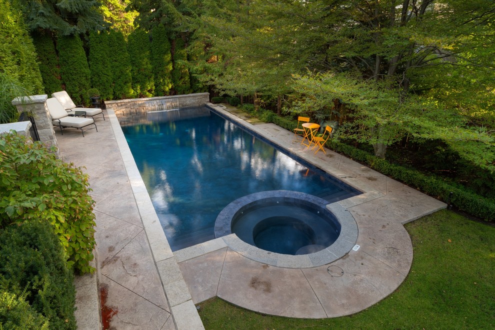 Inspiration for a mid-sized contemporary backyard rectangular pool in Toronto with a hot tub and stamped concrete.