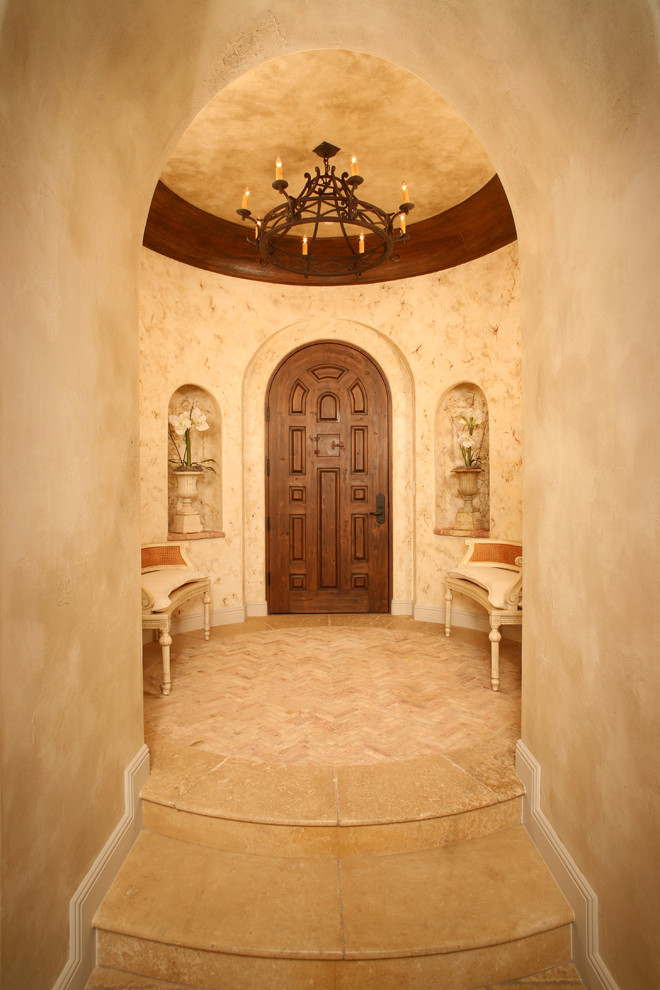 Design ideas for a mediterranean foyer in Orange County with beige walls, a single front door and a dark wood front door.