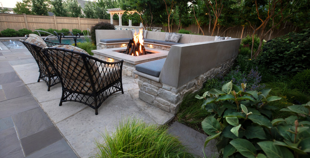 Photo of a large transitional backyard full sun formal garden for summer in Chicago with a fire feature and natural stone pavers.