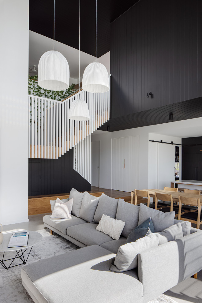 Offenes Modernes Wohnzimmer ohne Kamin mit schwarzer Wandfarbe und braunem Holzboden in Brisbane