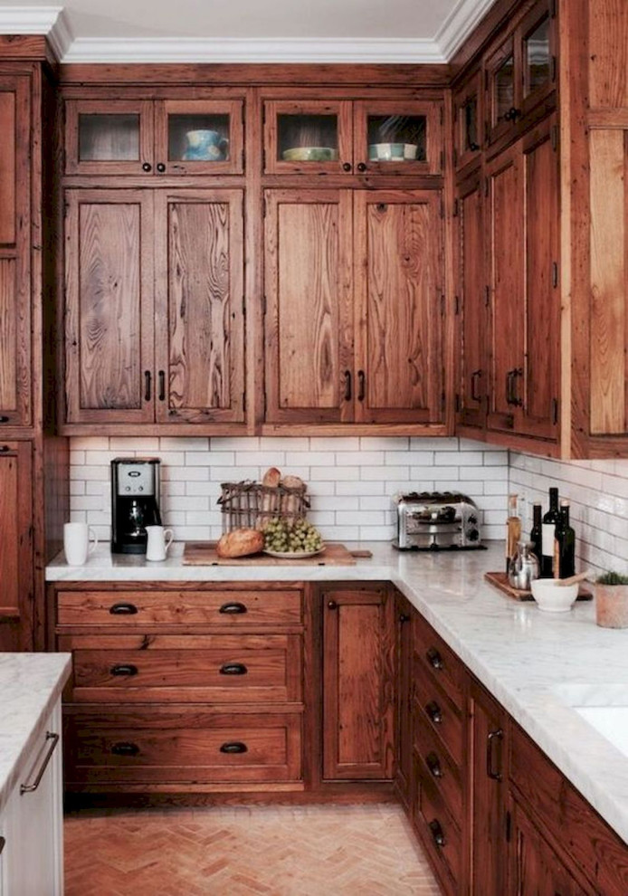 Design ideas for a large traditional l-shaped eat-in kitchen in Columbus with shaker cabinets, white splashback, stainless steel appliances, with island, brown floor, white benchtop, an undermount sink, medium wood cabinets, marble benchtops, subway tile splashback and ceramic floors.
