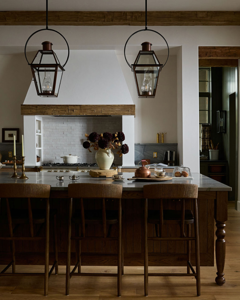 Rustic Refined - Country galley medium tone wood floor, brown floor and exposed beam kitchen photo in Oklahoma City with shaker cabinets, dark wood cabinets, gray backsplash, stone slab backsplash, white appliances, an island and gray countertops