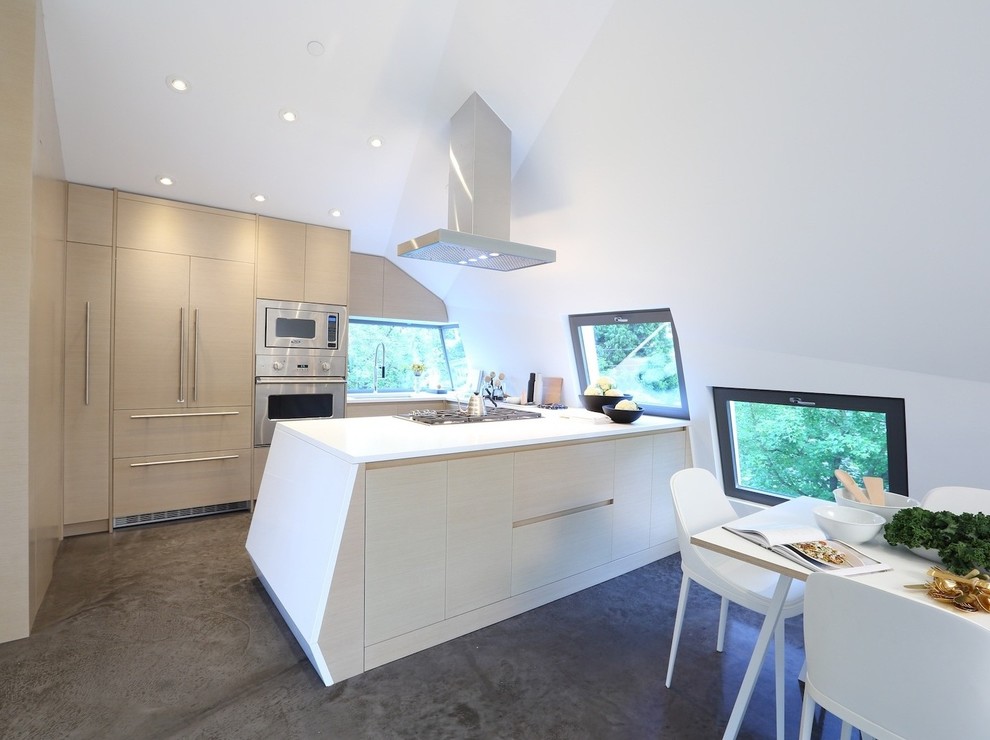 This is an example of a mid-sized contemporary u-shaped eat-in kitchen in Vancouver with an undermount sink, flat-panel cabinets, light wood cabinets, quartz benchtops, stainless steel appliances, concrete floors, a peninsula and brown floor.