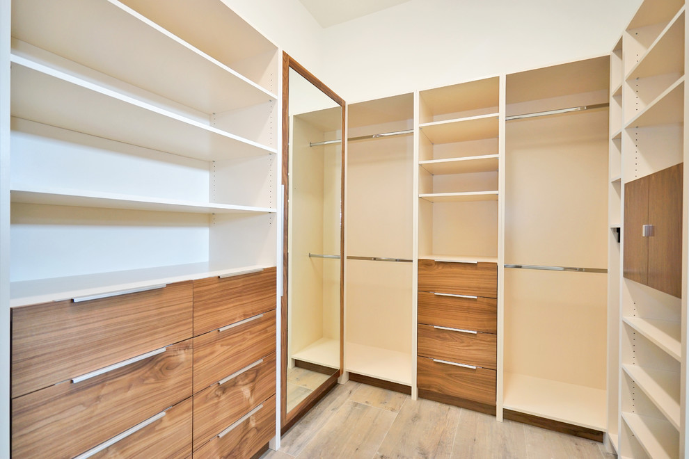 Inspiration for a large modern men's walk-in wardrobe in Miami with flat-panel cabinets, dark wood cabinets, laminate floors and brown floor.