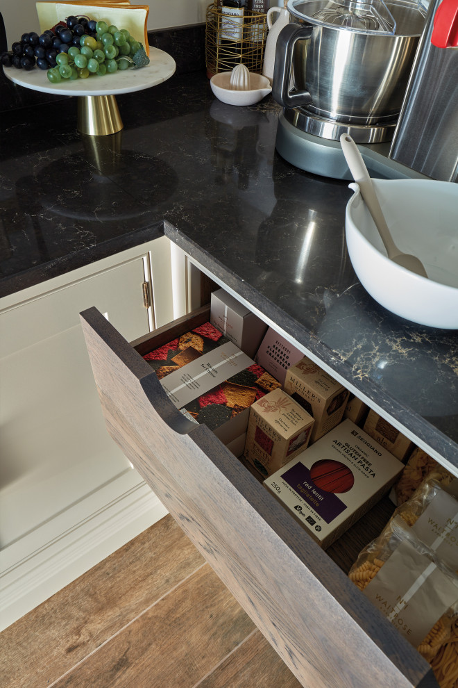 Inspiration for a small traditional l-shaped kitchen pantry in Manchester with grey cabinets, stainless steel appliances, porcelain flooring, no island, brown floors and black worktops.