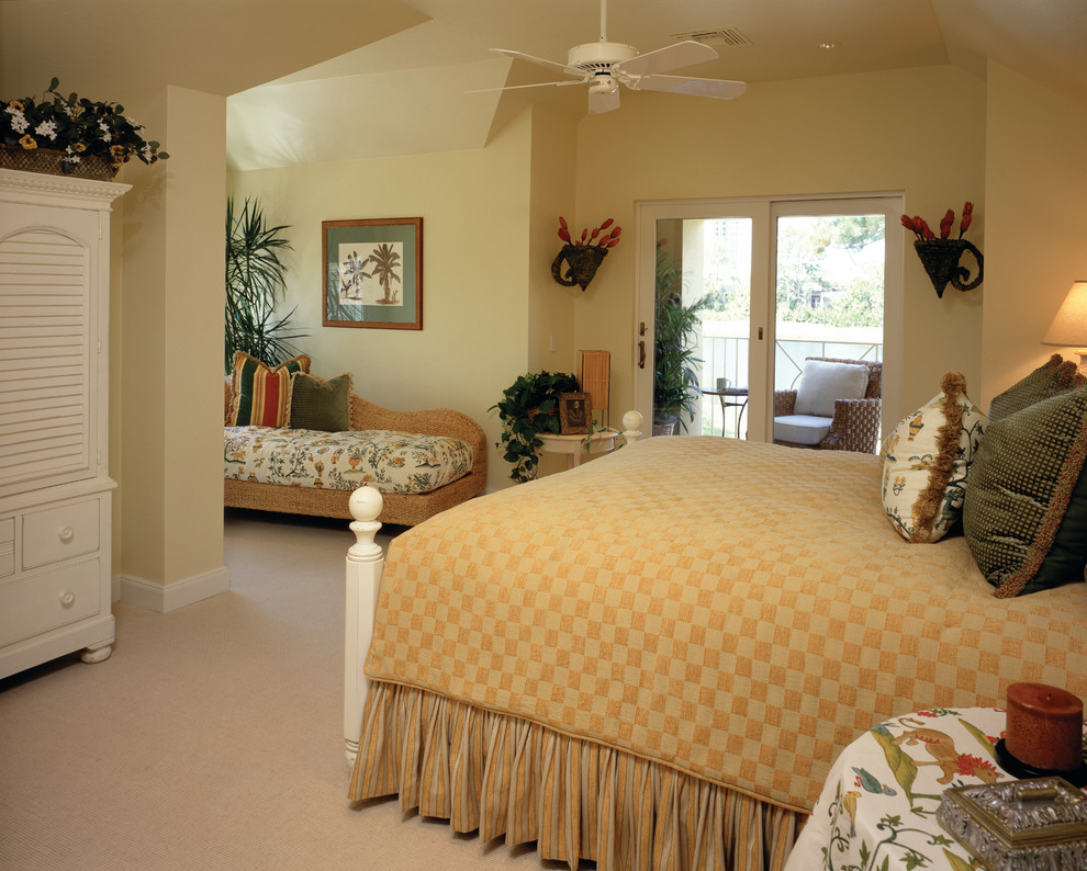 This is an example of an expansive tropical guest bedroom in Miami with yellow walls, carpet and no fireplace.