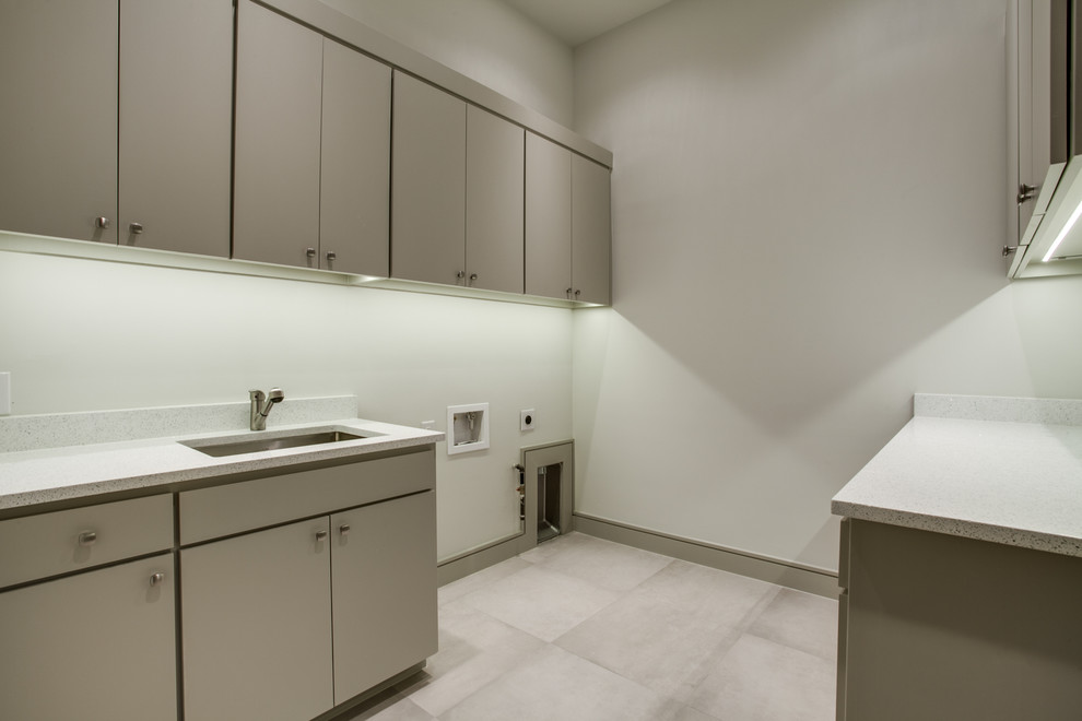 Expansive modern galley dedicated laundry room in Dallas with a drop-in sink, flat-panel cabinets, beige cabinets, quartz benchtops, beige walls, ceramic floors and a side-by-side washer and dryer.