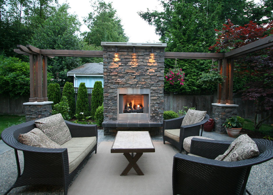Large contemporary backyard patio in Vancouver with a fire feature, stamped concrete and no cover.