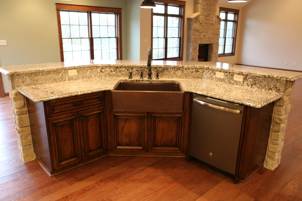 Large country l-shaped eat-in kitchen in Chicago with a farmhouse sink, granite benchtops, stainless steel appliances, with island, beaded inset cabinets, distressed cabinets, beige splashback, stone tile splashback and dark hardwood floors.