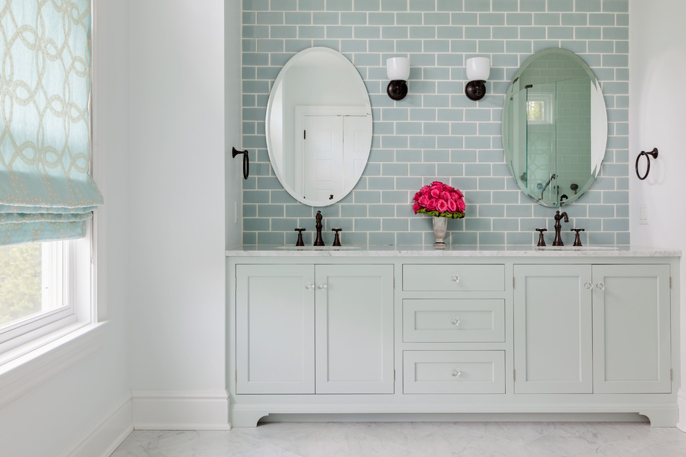 Photo of a beach style bathroom in Baltimore with blue cabinets, marble benchtops, blue tile, subway tile, marble floors, shaker cabinets and white walls.
