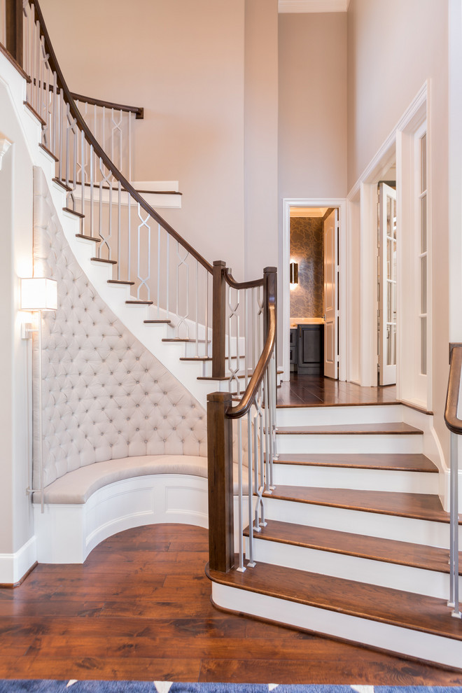 Photo of a large transitional wood curved staircase in Houston with painted wood risers and wood railing.