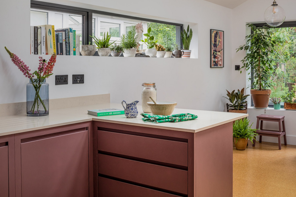Design ideas for a small contemporary u-shaped eat-in kitchen in West Midlands with a drop-in sink, flat-panel cabinets, purple cabinets, quartz benchtops, black appliances and cork floors.