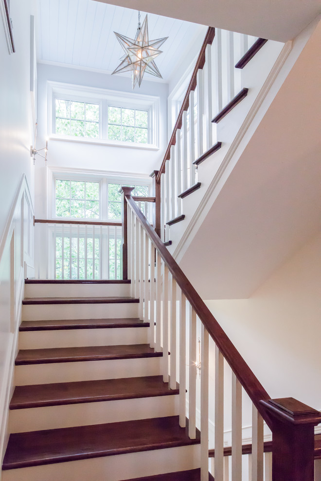 Country wood u-shaped staircase in DC Metro with painted wood risers and wood railing.