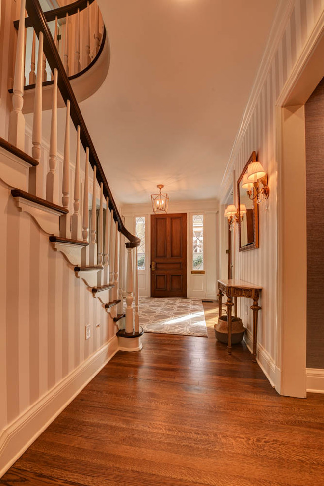 Mid-sized traditional foyer in New Orleans with multi-coloured walls, brown floor, dark hardwood floors, a single front door and a medium wood front door.