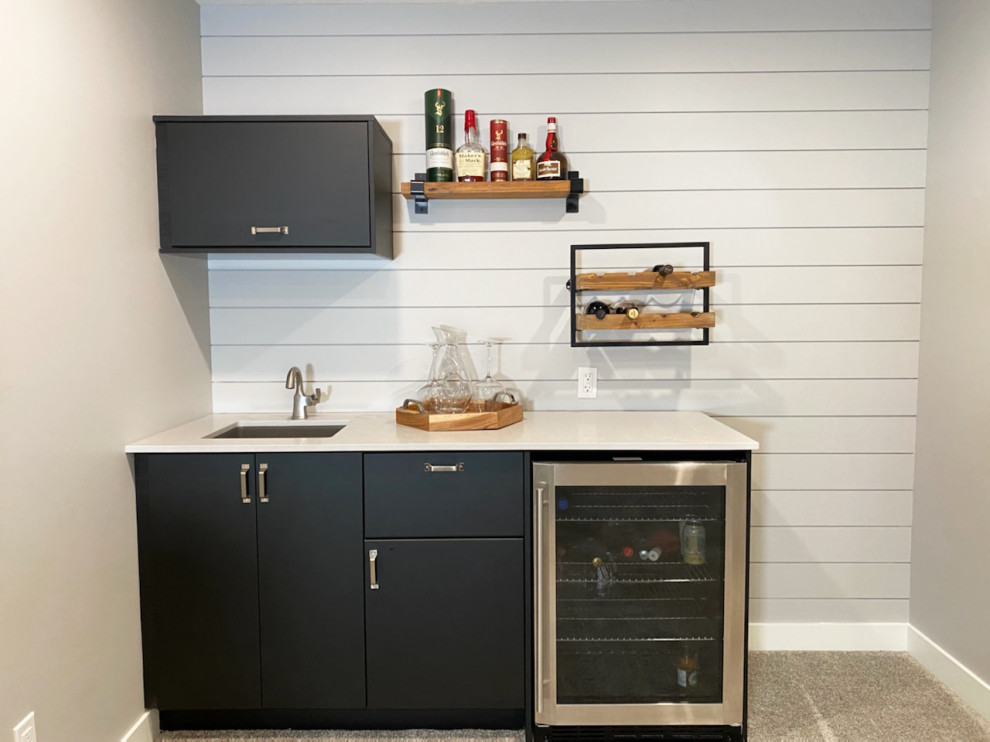 Photo of a medium sized urban single-wall wet bar in Calgary with carpet, grey floors, a submerged sink, flat-panel cabinets, black cabinets, engineered stone countertops, grey splashback, tonge and groove splashback and grey worktops.