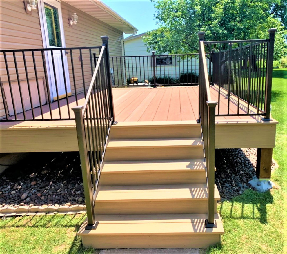 Photo of a mid-sized midcentury backyard and ground level deck in Minneapolis with no cover and metal railing.