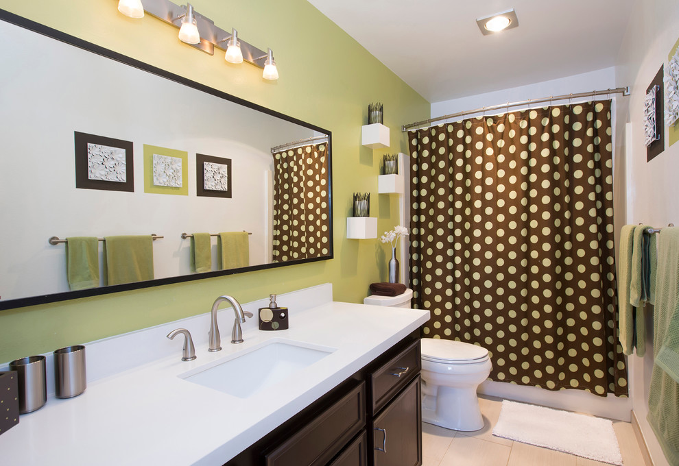 This is an example of a contemporary kids bathroom in San Diego with an undermount sink, raised-panel cabinets, dark wood cabinets, engineered quartz benchtops, a one-piece toilet, green walls and ceramic floors.