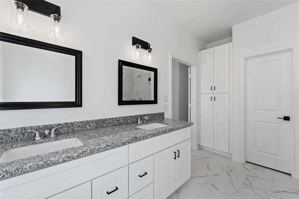 Photo of a mid-sized transitional master bathroom in Houston with shaker cabinets, white cabinets, white tile, ceramic tile, quartzite benchtops, grey benchtops, a double vanity, a built-in vanity, a drop-in tub, a corner shower, a one-piece toilet, white walls, porcelain floors, an undermount sink, white floor, a hinged shower door, an enclosed toilet, coffered and panelled walls.