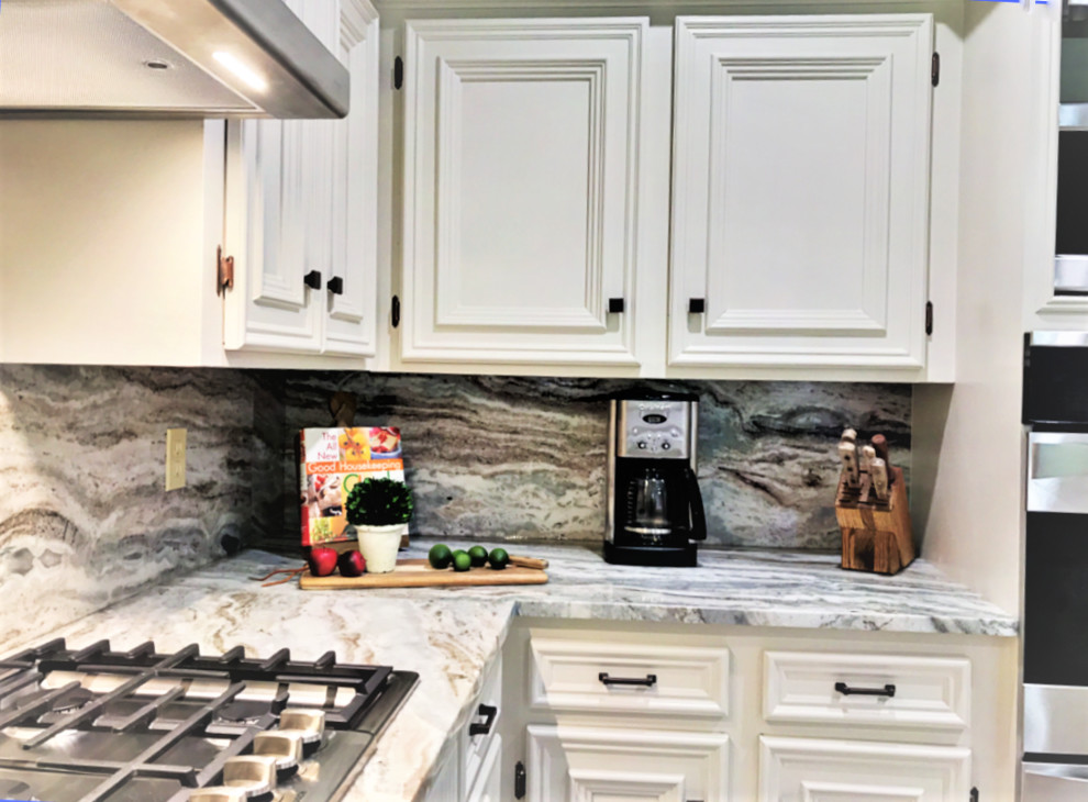 Large elegant u-shaped kitchen pantry photo in Houston with an undermount sink, recessed-panel cabinets, white cabinets, granite countertops, stone slab backsplash, stainless steel appliances and a peninsula