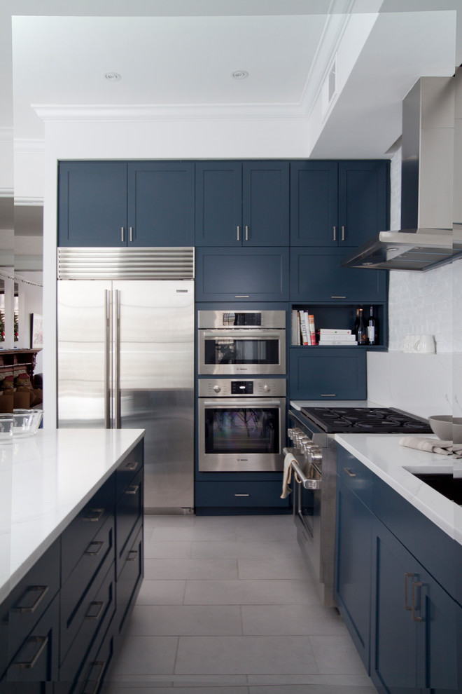 Design ideas for a mid-sized scandinavian l-shaped eat-in kitchen in New York with a single-bowl sink, shaker cabinets, blue cabinets, quartz benchtops, white splashback, brick splashback, stainless steel appliances, porcelain floors, with island and grey floor.
