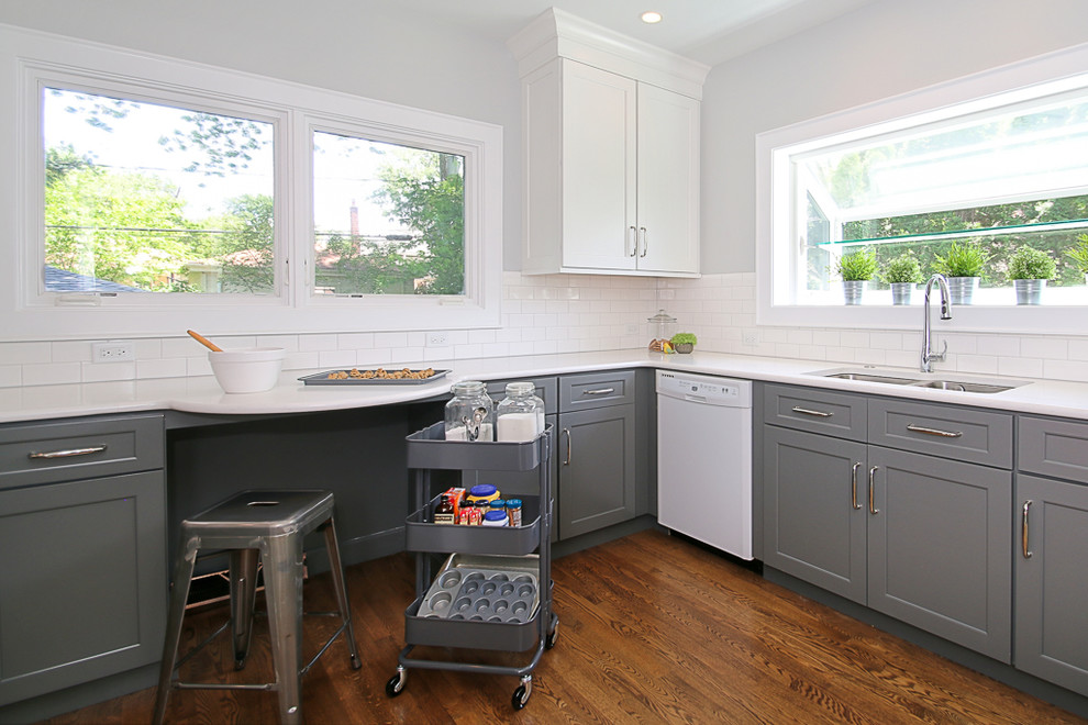 Small transitional u-shaped dark wood floor enclosed kitchen photo in Chicago with an undermount sink, shaker cabinets, white cabinets, quartz countertops, white backsplash, subway tile backsplash, white appliances and no island