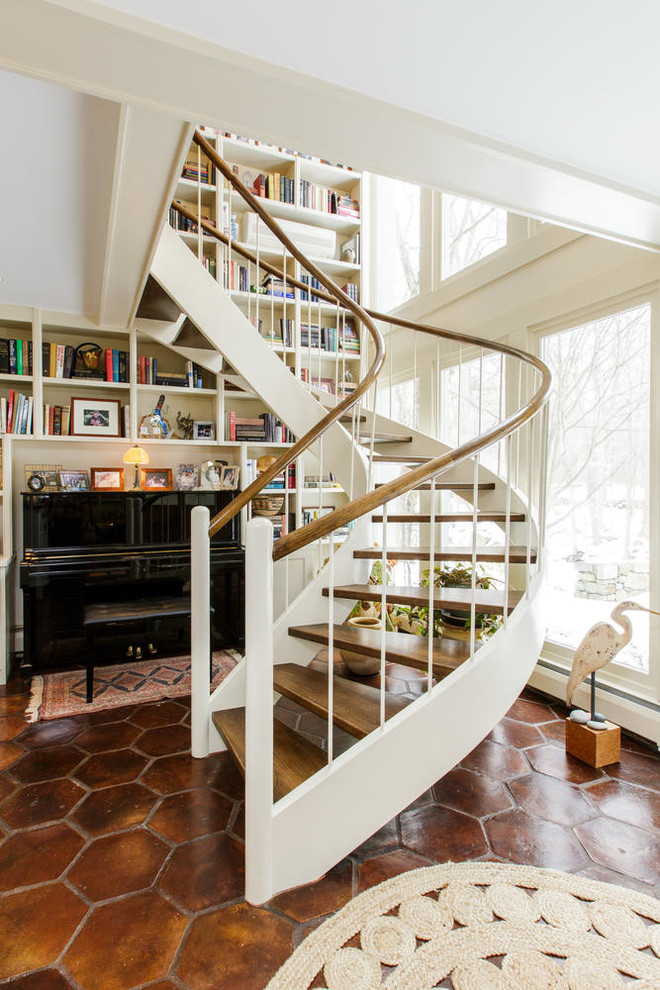 Mid-sized country wood curved staircase in New York with open risers and mixed railing.