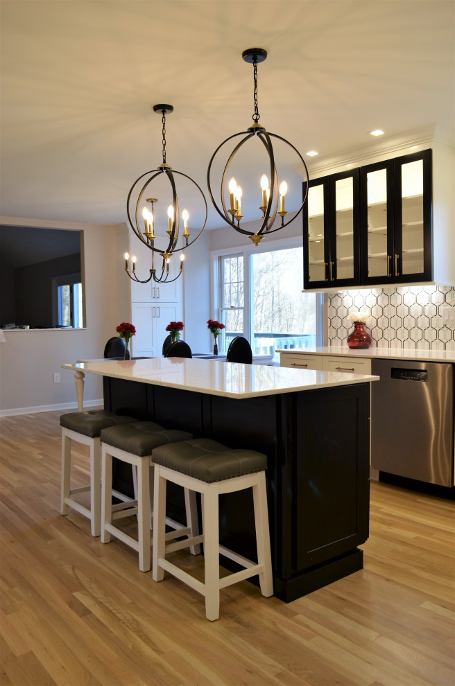 ニューヨークにある高級な中くらいなトランジショナルスタイルのおしゃれなキッチン (アンダーカウンターシンク、シェーカースタイル扉のキャビネット、白いキャビネット、クオーツストーンカウンター、黒いキッチンパネル、大理石のキッチンパネル、シルバーの調理設備、淡色無垢フローリング、ベージュの床、白いキッチンカウンター) の写真