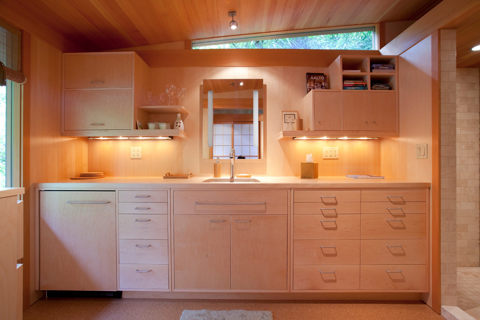 Photo of a small contemporary galley separate kitchen in Portland with no island, flat-panel cabinets, light wood cabinets, wood benchtops, beige splashback, a single-bowl sink and cork floors.