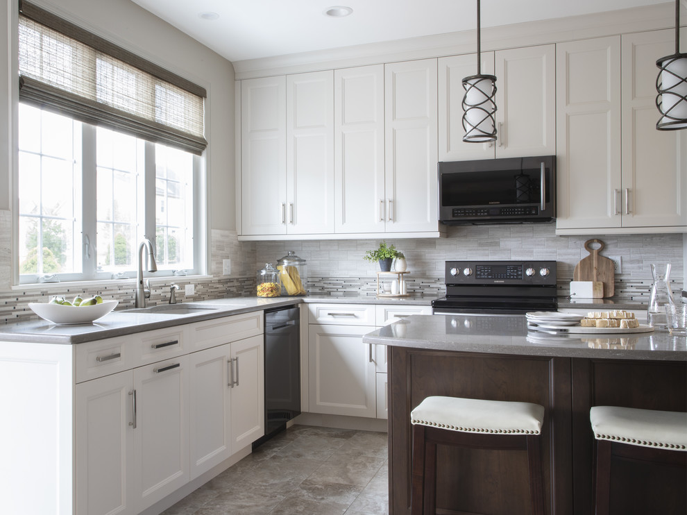 Example of a transitional porcelain tile and beige floor kitchen design with an undermount sink, beige backsplash, black appliances and an island