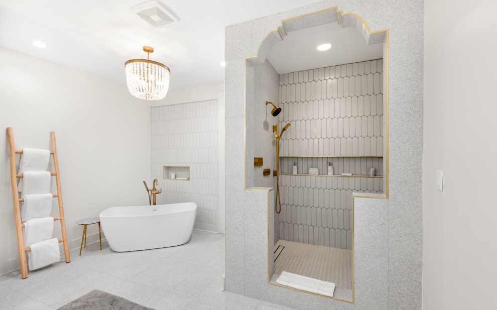 Lighting, gold tones, terrazzo tile in soft hues brightened up by antique gold faucet system with multiple head, Layered tile, shampoo niche, unique architectural design walk-in shower, specialty tile