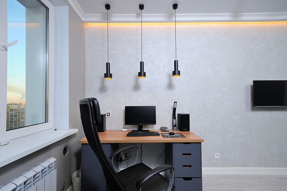 Пример оригинального дизайна: рабочее место среднего размера в современном стиле с серыми стенами, светлым паркетным полом, отдельно стоящим рабочим столом и серым полом