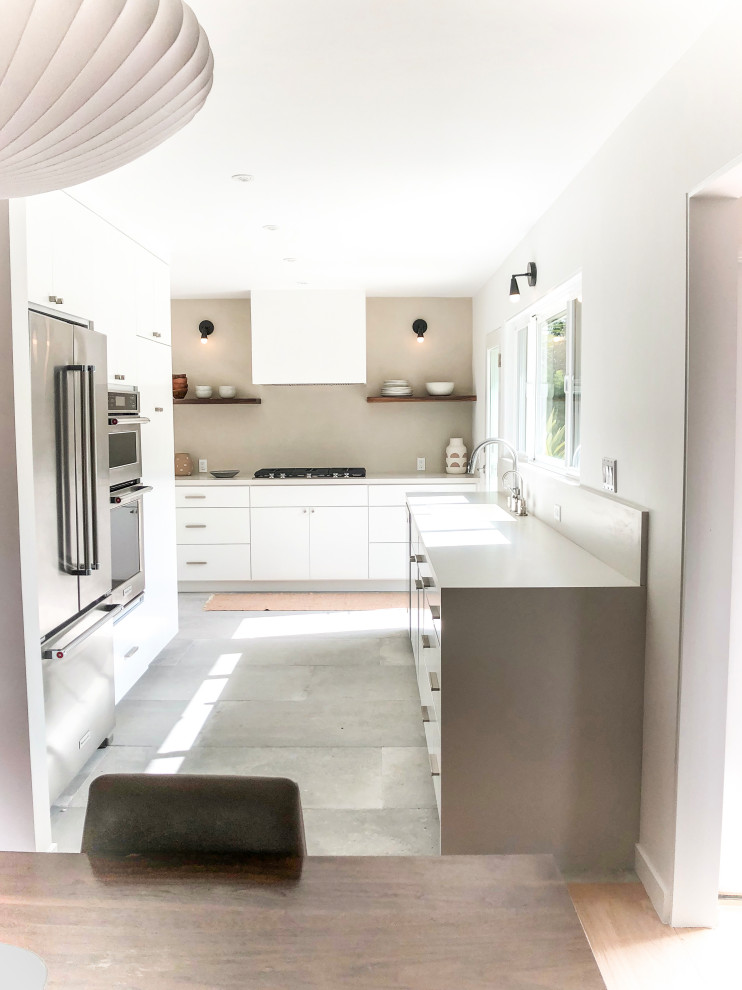 Mid-sized contemporary galley separate kitchen in Los Angeles with a single-bowl sink, flat-panel cabinets, white cabinets, quartz benchtops, brown splashback, stainless steel appliances, cement tiles, no island, grey floor and grey benchtop.