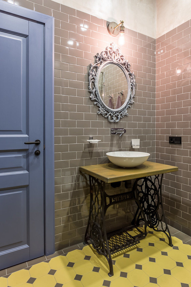 Industrial bathroom in Moscow with yellow tile, gray tile, grey walls and a vessel sink.