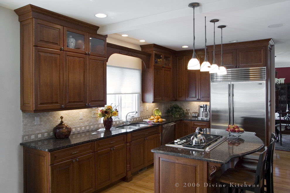 Design ideas for a mid-sized traditional l-shaped eat-in kitchen in Boston with a double-bowl sink, beaded inset cabinets, dark wood cabinets, granite benchtops, beige splashback, stone tile splashback, stainless steel appliances, light hardwood floors and with island.
