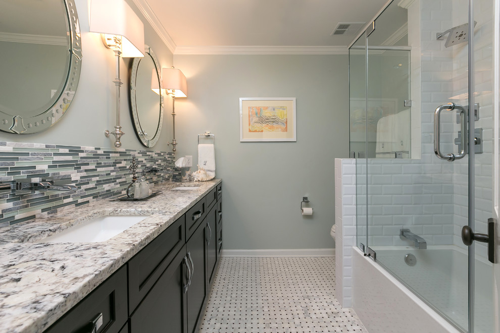 This is an example of a mid-sized traditional kids bathroom in Charleston with a drop-in sink, recessed-panel cabinets, black cabinets, granite benchtops, a drop-in tub, a shower/bathtub combo, gray tile, matchstick tile, grey walls and ceramic floors.