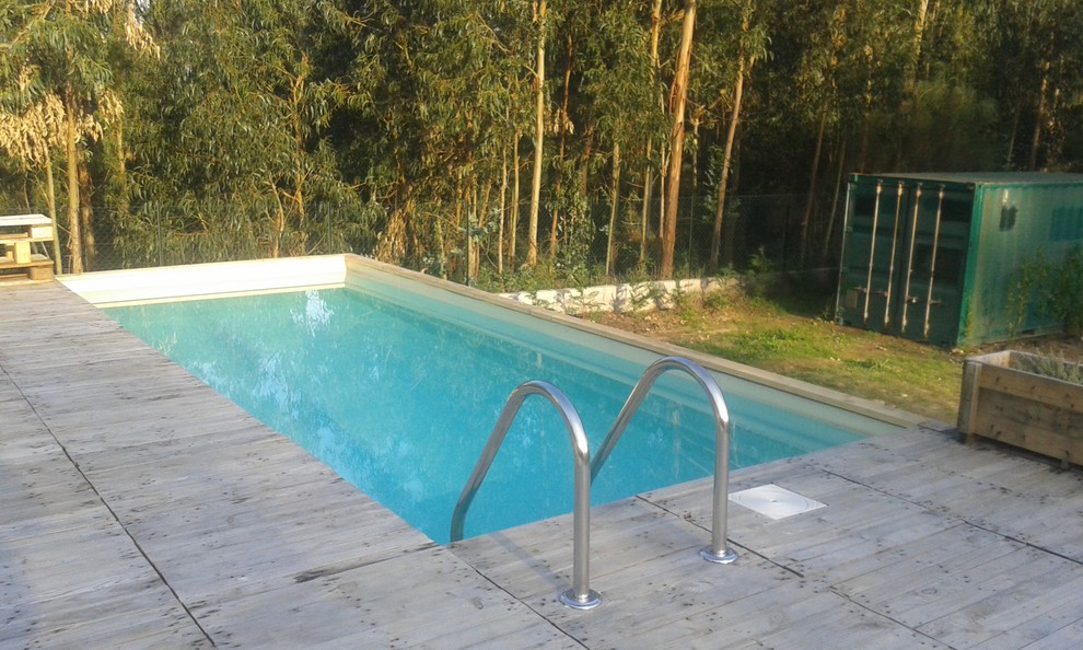 This is an example of a small country backyard rectangular aboveground pool in Other with decking.