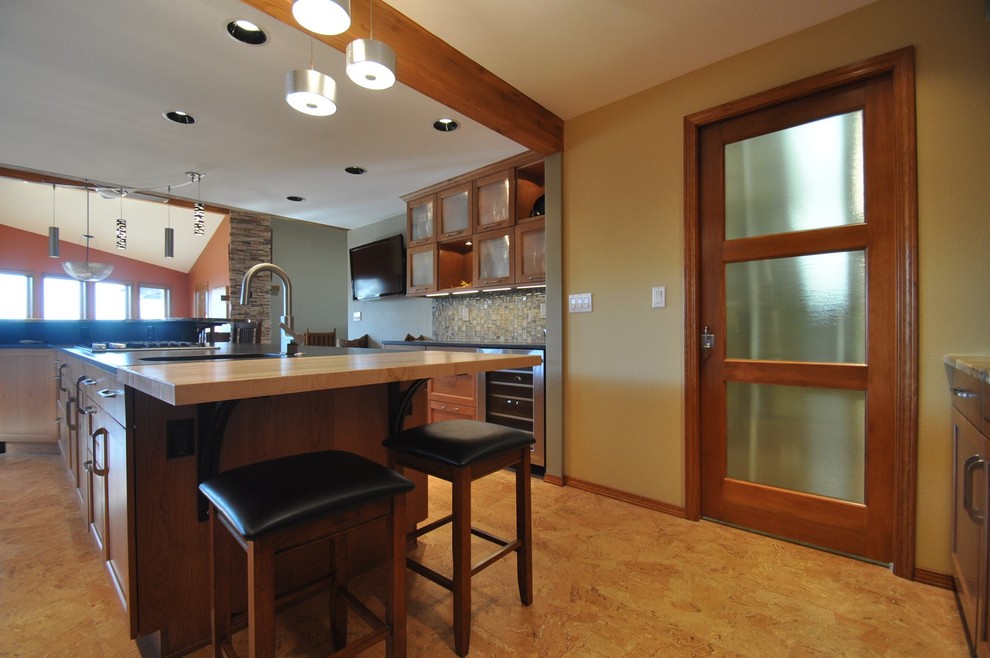 Example of a large mountain style u-shaped eat-in kitchen design in Boise with a double-bowl sink, glass-front cabinets, light wood cabinets, soapstone countertops, matchstick tile backsplash, stainless steel appliances and two islands