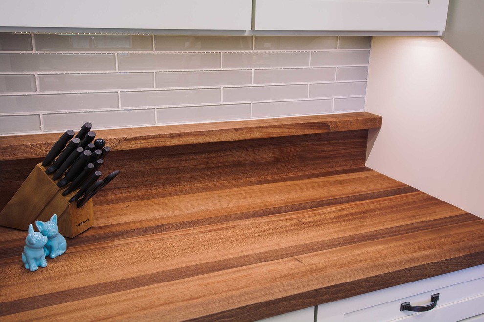 Small transitional galley vinyl floor eat-in kitchen photo with recessed-panel cabinets, white cabinets and gray backsplash