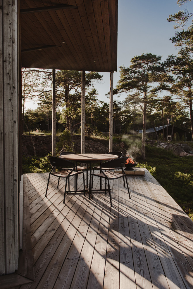 Design ideas for a large scandinavian side yard deck in Stockholm with a roof extension.