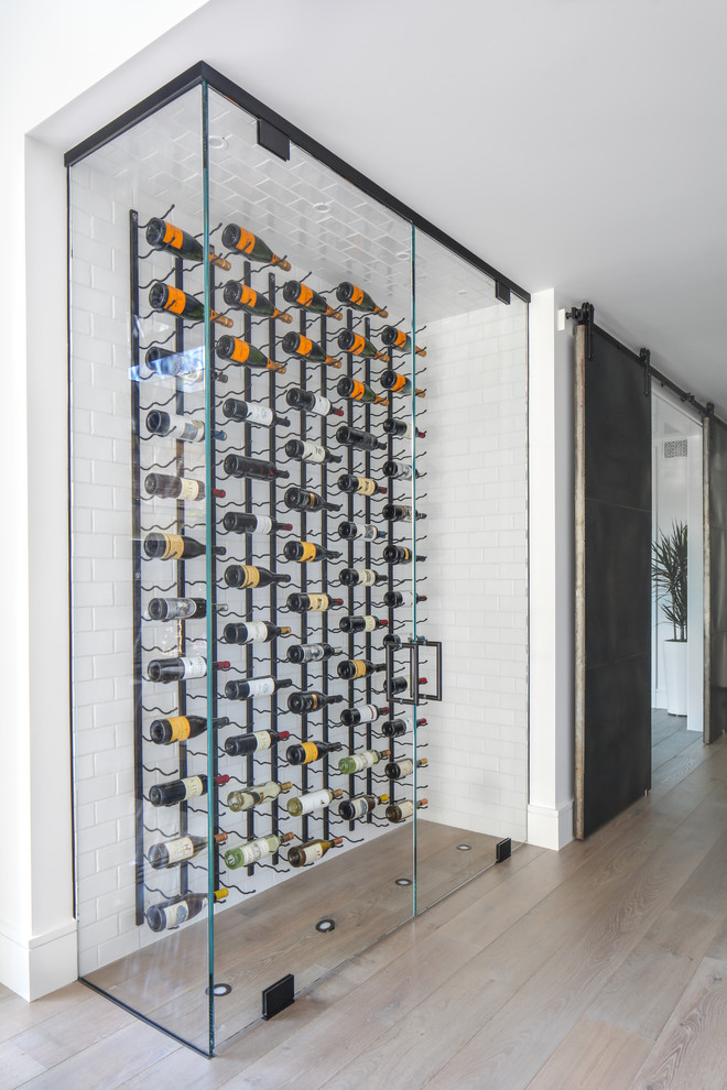 Inspiration for a small modern medium tone wood floor and brown floor wine cellar remodel in Orange County with display racks