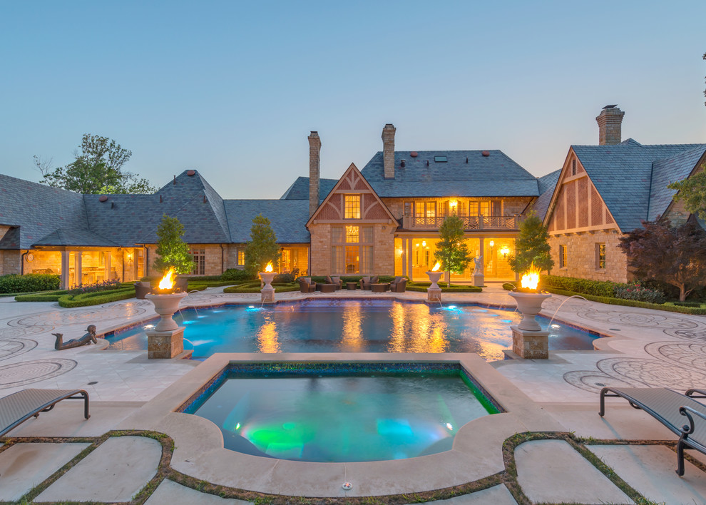 This is an example of a large traditional courtyard custom-shaped pool in Dallas with a hot tub.
