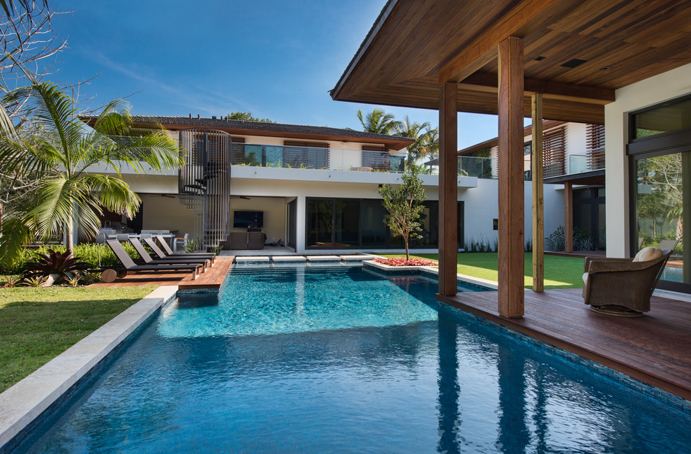 Contemporary custom-shaped pool in Miami with decking.