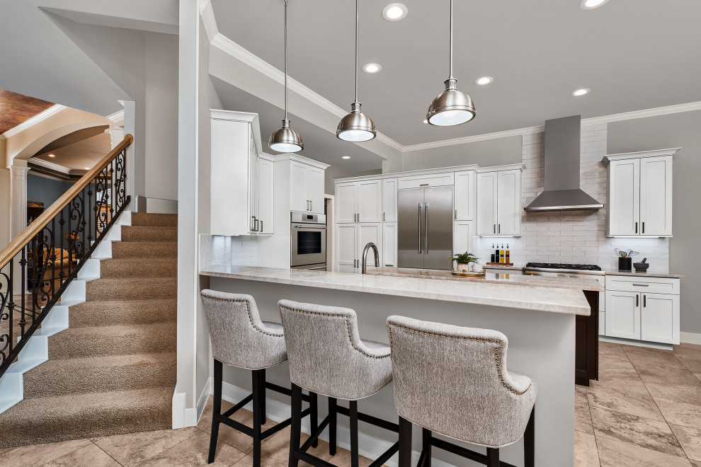Transitional u-shaped porcelain tile and beige floor kitchen pantry photo with shaker cabinets, white cabinets, quartzite countertops, white backsplash, porcelain backsplash, stainless steel appliances, an island and beige countertops