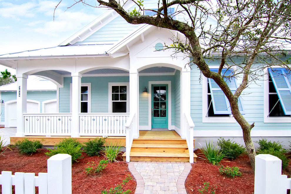 Mid-sized beach style one-storey blue house exterior in Jacksonville with wood siding and a metal roof.