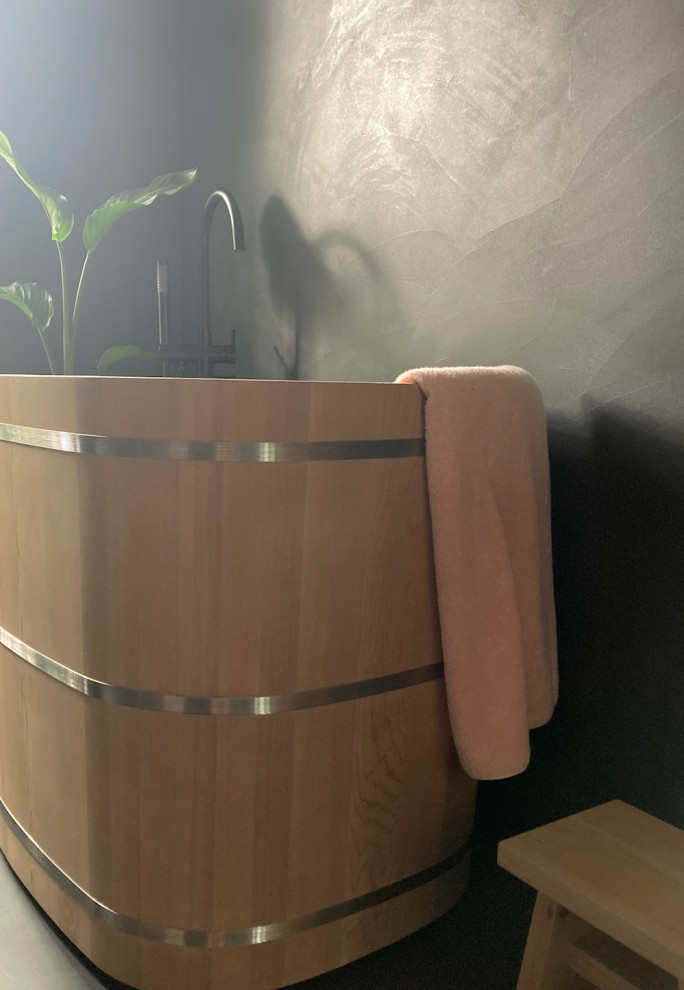 Пример оригинального дизайна: большая ванная комната в стиле фьюжн с японской ванной, душем без бортиков, инсталляцией, розовой плиткой, керамической плиткой, серыми стенами, бетонным полом, раковиной с несколькими смесителями, столешницей из дерева, серым полом, душем с распашными дверями, коричневой столешницей и тумбой под две раковины